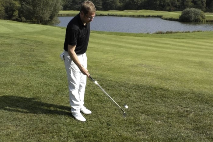 Ball mit Golfschläger aufheben